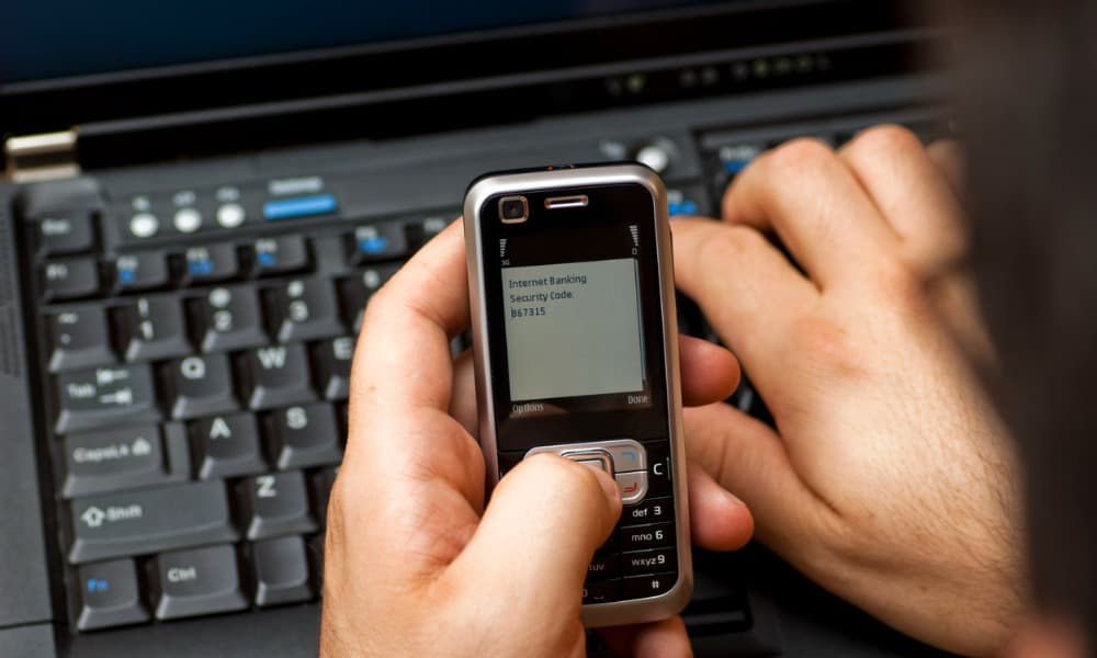 A hand holding a phone with a Craigslist phone number verification code.